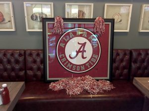 Alabama Crimson Tide sign with Alabama shakers on table.