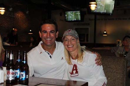 Two pepple with white shirts on sitting in dim light room.