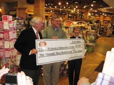 Group of people holding poster in front of display.