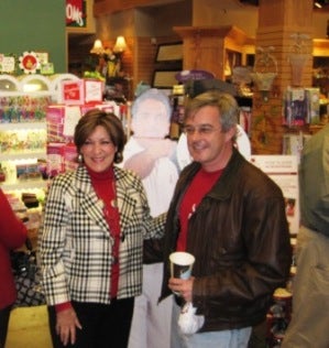 Terry Saban and man in dark jacket standing in room with green wall.