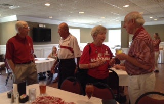 Group of people standing behind a table in dim light room.