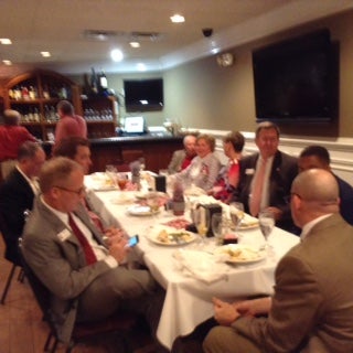 Group of people sitting at a table in a dim light room.