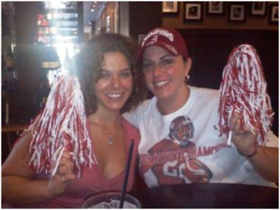 Two ladies holding Alabama Shakers in dim light room.