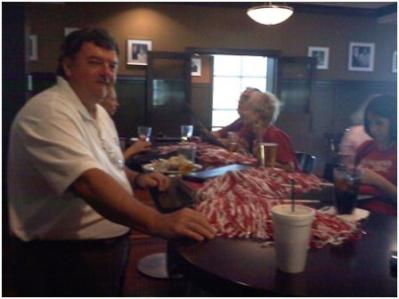 Man in white shirt sitting at table in dim light room