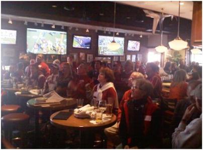 Group of people sitting at tables in dim light room.