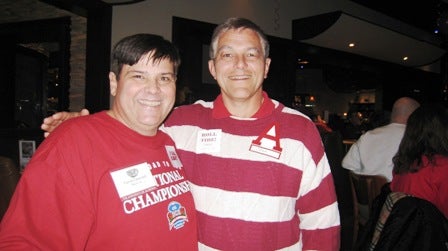Two people standing with Red and White shirts on.
