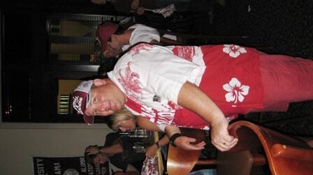 One man standing with group of people in background.