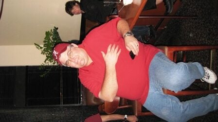 Man in Red shirt sitting on bar stool.