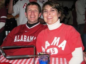 Two people with red shirts on sitting at table.