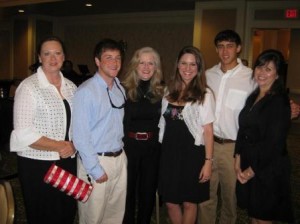 Group of people standing in dim room.