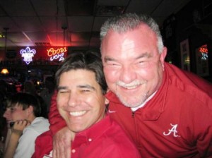 Two people in red shirts in dim room.