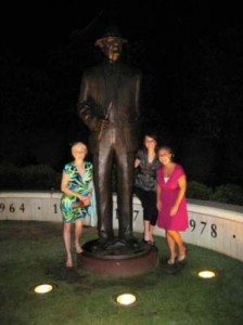 Group of people standing by statue at night.