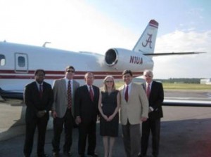 Group of people standing in front of airplane.