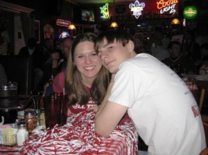 Two people sitting at table in dim room.