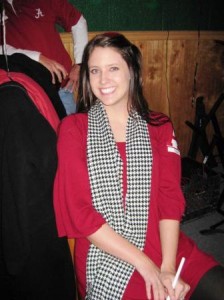 One person in red shirt and houndstooth scarf sitting in room.