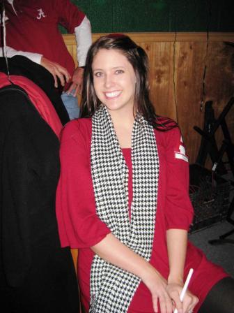 One person in red shirt and houndstooth scarf sitting in room.