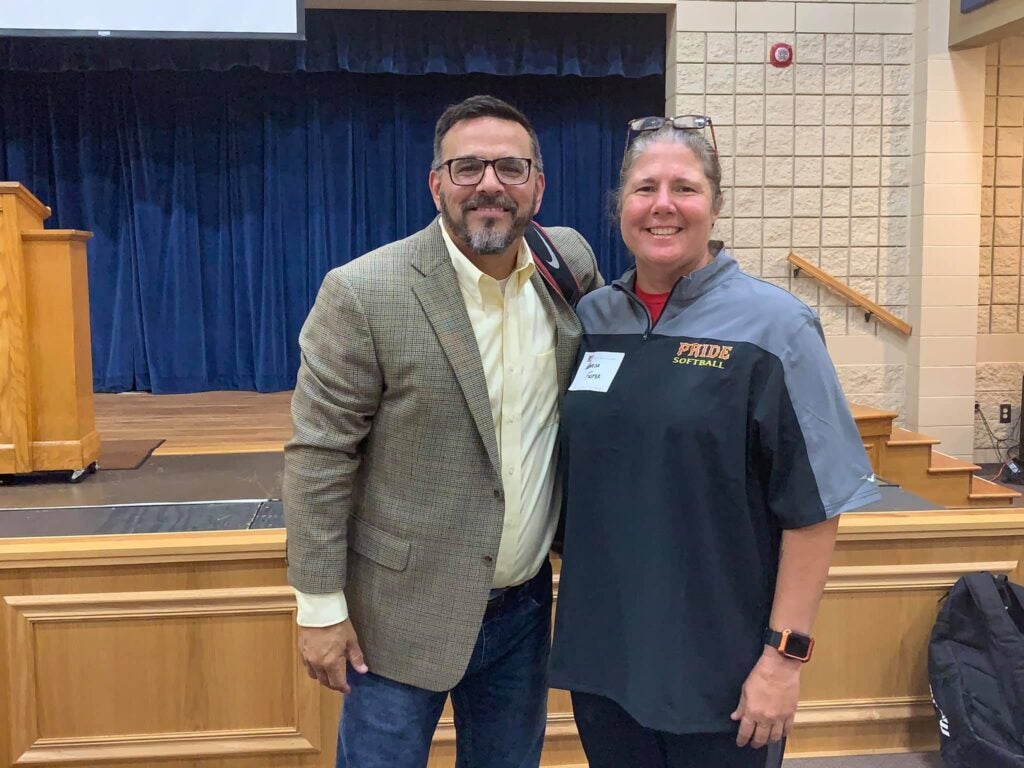 two people standing in front of blue curtain