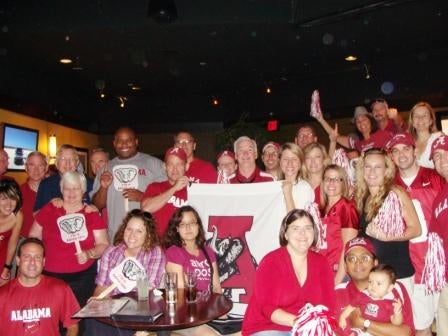 Group of people with Alabama Flag sitting outside at night