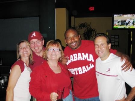Group of people in red and white shirts standing in dark room