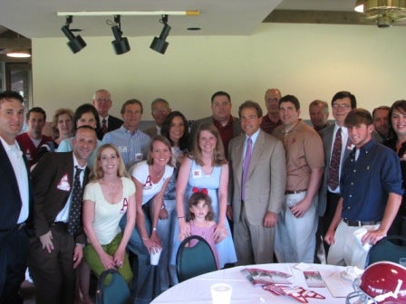 Group of people standing in room with beige walls.