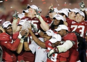 Group of Alabama footall players in red and white jerseys.