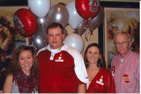 Group of people standing in front of balloons.