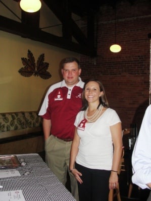 Two people standing in room with dim light.