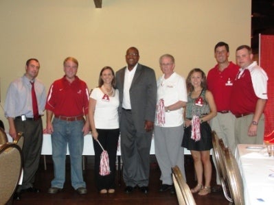 Group of people standing in front of beige wall.