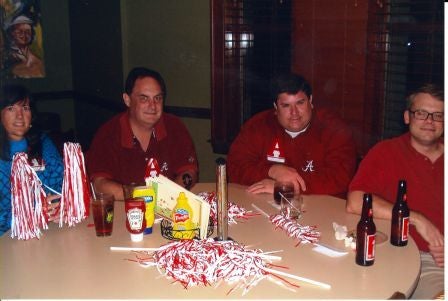 Group of people sitting behind table in a dim light room.