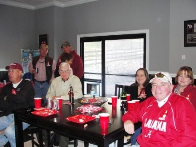 Group of people sitting at table in front of window.