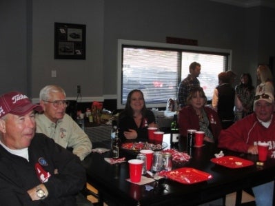 Group of people sitting at table in dim light room.