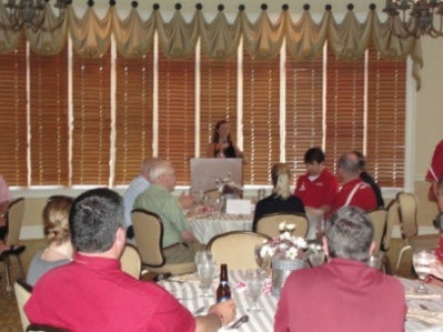 People sitting in room and person behind a podium.