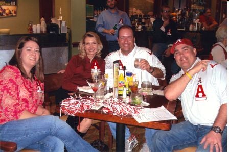 Group of people sittig at a table in dim light room.