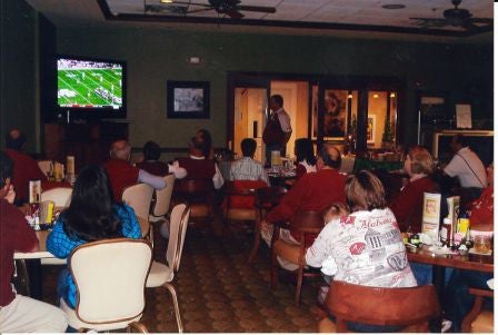 Group of people sittig at a table in dim light room.