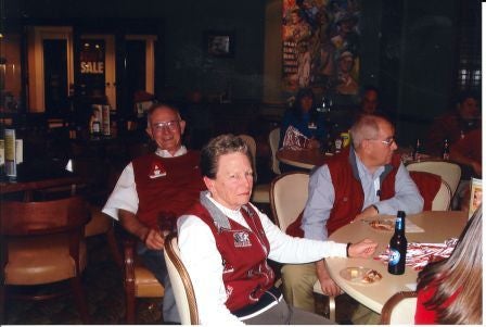 Group of people sittig at a table in dim light room.