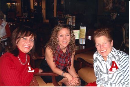 Group of people sittig at a table in dim light room.