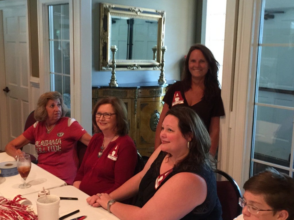 Group of people sitting in a room behind a table.