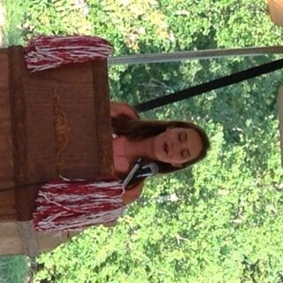 Student standing behind podium outside under a tent.