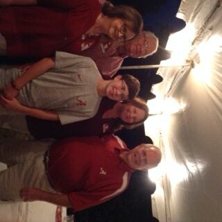 Group of people stanidng under a tent outside at night.