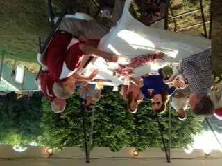 Group of people sitting at table outside under a tent.