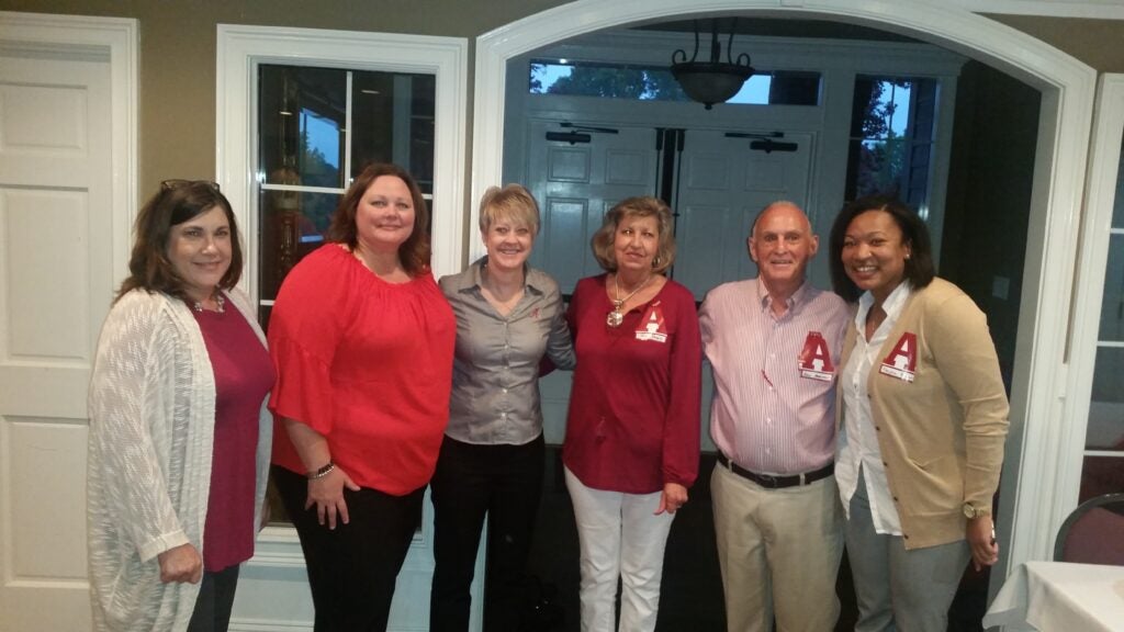 Group of people standing in room with dim light.