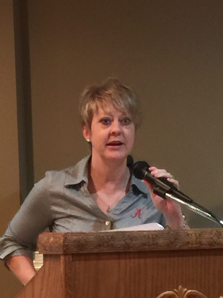 Lady standing behind podium.