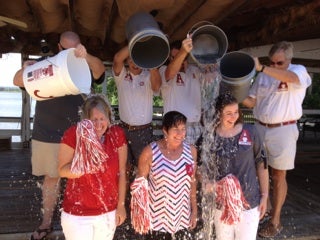 Group of people standing and holding red and white shakers.