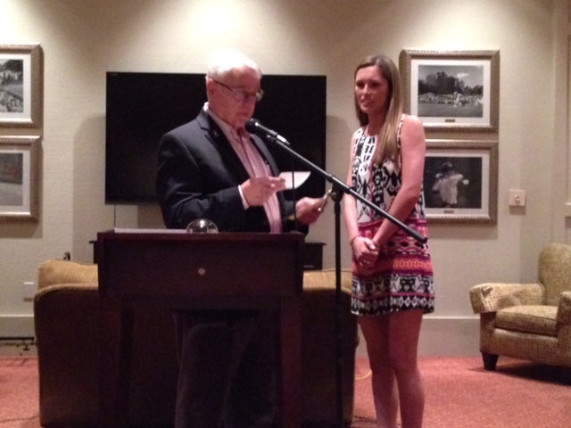 Man in dark suit and girl in black/white dress standing in front of black/white wall.