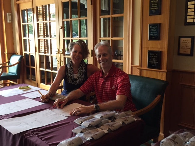 Two people sitting at desk in front of brown glass door.