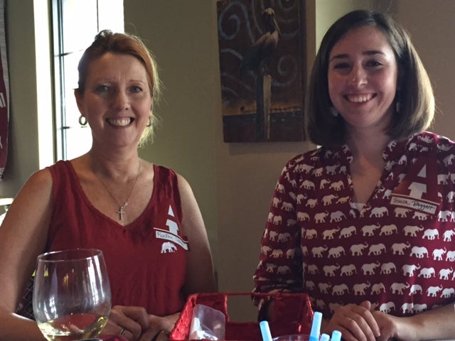 Two ladies sitting in room with white wall.