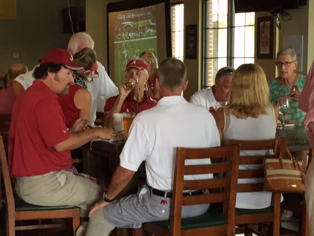 Group of people sitting at table in front of window.