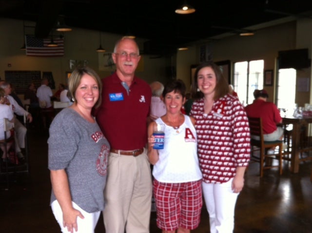 Group of people standing in room with dim light.
