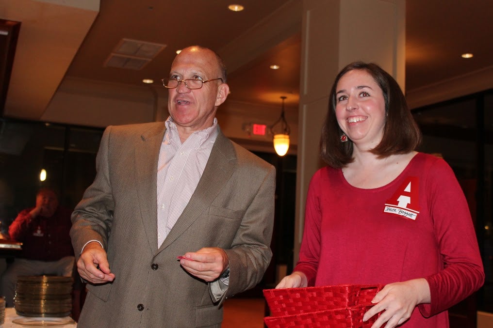 Dean Chuck Karr and Lady in red dress in dim light room.