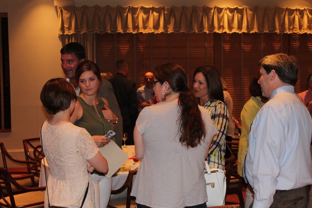Group of people standing in room with dim light.